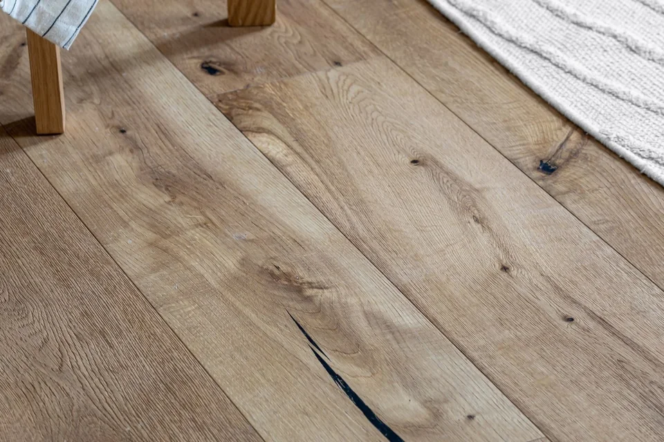 Parquet en chêne à larges lames près d'un tapis